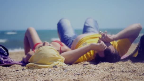 对年轻情侣躺在海面上休息和旋转整流罩在他的手中。高清，1920 x 1080。慢动作 — 图库视频影像