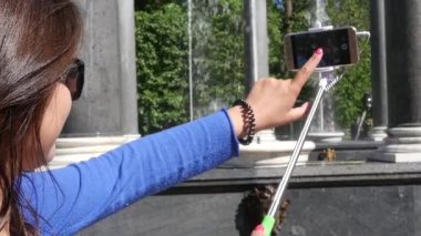 Kız bir fotoğraf çekmek için belgili tanımlık telefon perde parmağına tıklatır. ağır çekim. 1920 x 1080. hd tam.