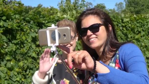 Duas jovens namoradas fazem uma foto no telefone e um pau de selfie. câmara lenta. 1920x1080. hd completo — Vídeo de Stock