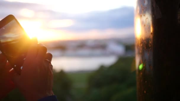 Haga un panorama fotográfico en el teléfono con una vista de la puesta del sol y la ciudad. cámara lenta, 1920x1080, full hd — Vídeo de stock