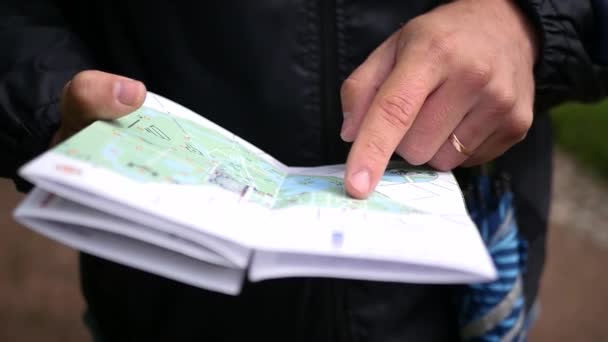 A young man looks at a paper map, checks the route. slow motion, 1920x1080, full hd — Stock Video