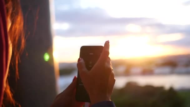 Faça uma foto no telefone de um belo pôr do sol na cidade perto do rio. câmera lenta, 1920x1080, hd completo — Vídeo de Stock