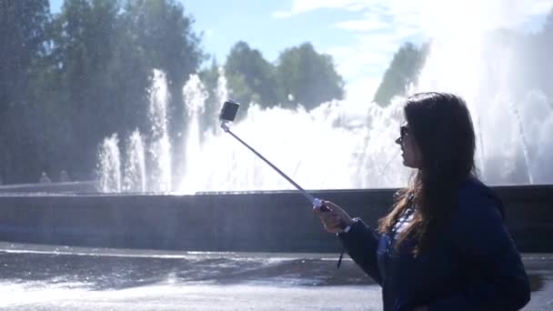 Menina tira um panorama fotográfico em uma fonte com um spray. câmara lenta. 1920x1080. hd completo — Vídeo de Stock