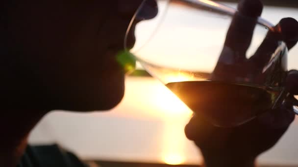 Un homme avec un verre dans les mains buvant du vin au coucher du soleil, gros plan. HD, 1920 x 1080. au ralenti — Video