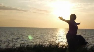 Genç bir kız güneşin tadını çim zemin güneşin ve denizin, karşı dönüyor. 4k, 3840 x 2160. HD