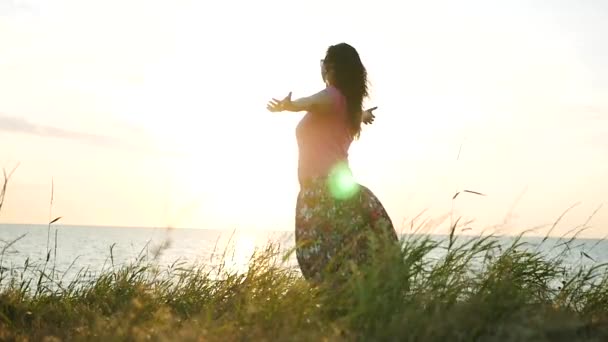 Дівчина здивована заходом сонця біля моря, піднімає руки. HD, 1920x1080. повільний рух . — стокове відео