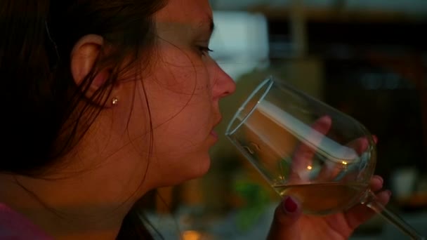 Ragazza seduta in un bar a bere vino bianco da un bicchiere, primo piano. HD, 1920x1080. rallentatore . — Video Stock