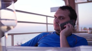 Bir iş adamı denizin kenarında bir kafede oturan ve Evet. HD, 1920 x 1080. ağır çekim.