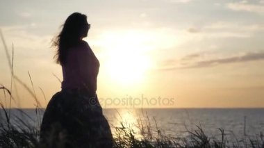 Genç bir kız güzel batımını denizin kenarında duruyor. 4k, 3840 x 2160. HD