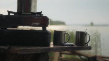 Bir gaz sobası, yakın bir göl güzel güneş parlamak üstünde o ile sabahı kaynatın. yakın çekim. 4k, 3840 x 2160. HD