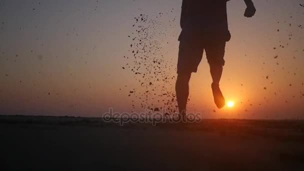 Człowiek działa boso na plaży o zachodzie słońca. HD, 1920 x 1080. zwolnionym tempie. — Wideo stockowe