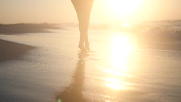 Marcher dans le sable près de l'eau au coucher du soleil. HD, 1920 x 1080. au ralenti . — Video