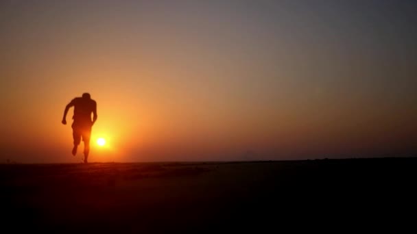 Egy ember, a naplemente fut mezítláb a homok. HD, 1920 x 1080. lassú mozgás. — Stock videók