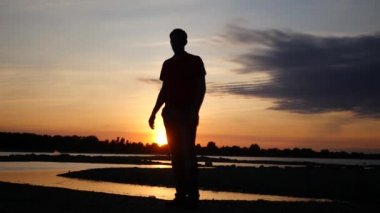 Sevgi dolu bir çift bir tarihte bir gün batımı ile nehrin yanında bir erkek bir kadın onun kollarında çember. HD, 1920 x 1080. ağır çekim.