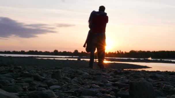 Pareja enamorada, abrazos y giros al atardecer junto al río. HD, 1920x1080. cámara lenta . — Vídeos de Stock