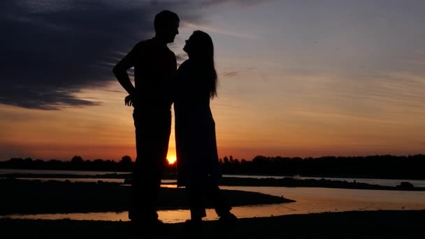 Romantischer Abend bei einem eitlen Paar am Fluss bei Sonnenuntergang, umarmt bewundernde Aussicht. hd, 1920x1080. Zeitlupe. — Stockvideo