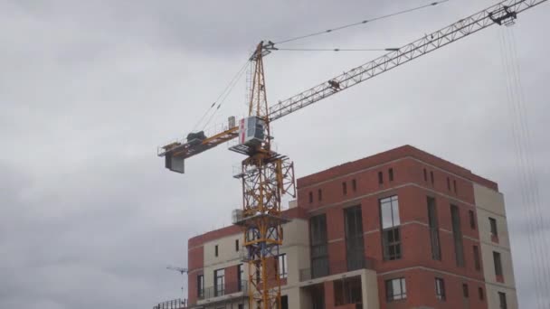 Move the construction crane on a construction site against a cloud background. time laps, 3840x2160, 4K — Stock Video