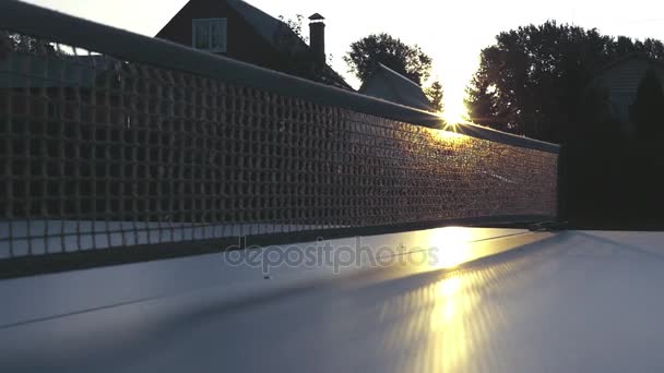 Grille sur une table de tennis en gros plan dans les rayons du coucher du soleil. au ralenti, 1920x1080, en haute qualité — Video