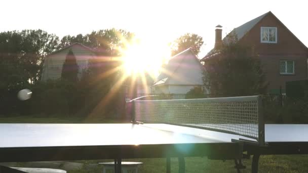 Para jogar uma bola de tênis de mesa no campo nos raios do pôr do sol. câmera lenta, 1920x1080, hd — Vídeo de Stock