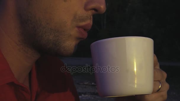 A young and attractive man drinks hot tea or coffee, in profile, close-up. slowmotion, 1920x1080, hd — Stock Video