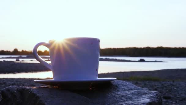 Záři paprsků zapadajícího slunce jít na okraji bílý hrnek s horkou kávou. detail. slowmotion, 1920 x 1080, hd — Stock video