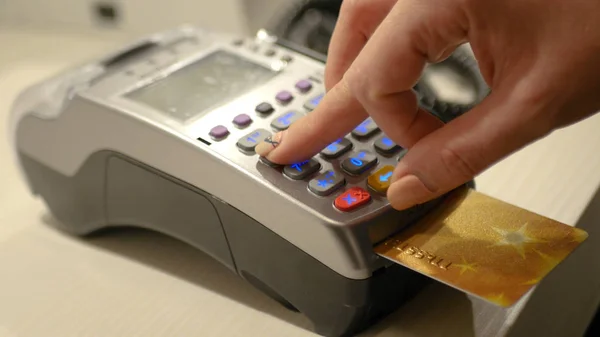 Banka terminalinden bir kart tutuyor. Hd