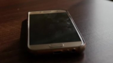 Güzel bir smartphone penceresinden parlama ile masada yatıyor. Slowmotion, Hd, 1920 x 1080