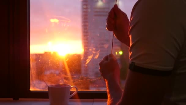 Abaissez les stores sur la fenêtre en vous cachant du beau coucher de soleil, avec un délicieux thé chaud sur le rebord de la fenêtre. ralenti, En Haute Qualité, 1920x1080 — Video