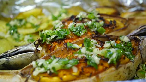 Baked fish with potatoes, vegetables and lemon, turns on a plate in front of the camera. HD, 1920x1080, slow motion — Stock Video