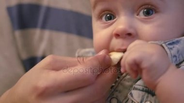 Papa'nın küçük oğlu onun kollarında tutar ve ona lezzetli yemek yemek için yardımcı olur. ağır çekim, 1920 x 1080, tam hd