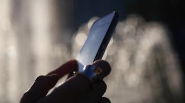 Bir kız ile güzel bir yüzük parmağına ve elleri, bir telefon ile tıklama ile güzel bir artalanları ekranda. HD, 1920 x 1080. ağır çekim.