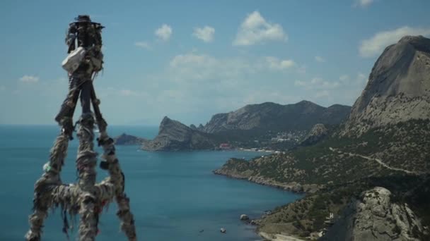 Beautiful scenery from a height on a rocky coast and the sea, and a column bandaged with ribbons. HD, 1920x1080. slow motion. — Stock Video