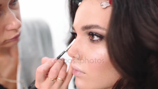 Maquillaje artista dibuja flechas, maestro de la cara hace maquillaje de ojos, mujer ven al salón de belleza, mujer pedir maquillaje artista para hacer ojos ahumados — Vídeo de stock