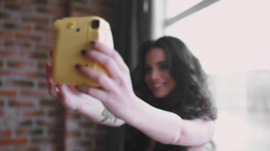 Güzel genç kadın selfie tarafından anlık fotoğraf makinesi, çekici beyaz kız kendini çekim yapar.