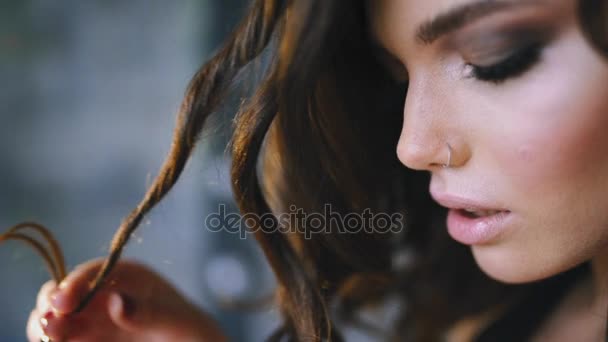 Szexi kaukázusi nő hosszú göndör barna haj, flörtöl lány, szép arcú nő portréja lány fordulat hair ujját — Stock videók