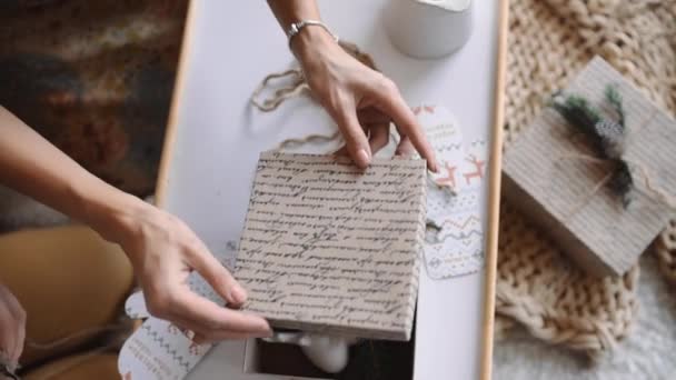 Mujer paquetes de regalos para el año nuevo, regalos de Navidad para niños, figuras de yeso en la caja de Navidad, recuerdos y juguetes para las vacaciones — Vídeos de Stock