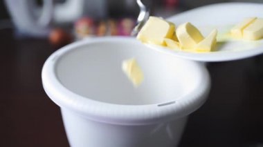 Aşçı tereyağı mutfakta yemek yemek için ekler, ev hanımı akşam yemeği hazırlar