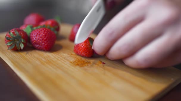 Fresa para decorar la cocción, el cocinero rebanadas fresas, bayas frescas en la cocina — Vídeo de stock