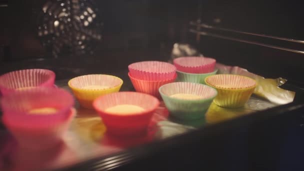 Cupcakes i ugnen, baker gör cupcakes, hemmafru bakar, matlagning i köket — Stockvideo