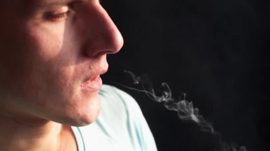 Adam elektronik sigara içiyor ve burun yoluyla Buhar off sağlar, biri vaping, e-cig ve vape kalem, insanların kötü alışkanlıkları