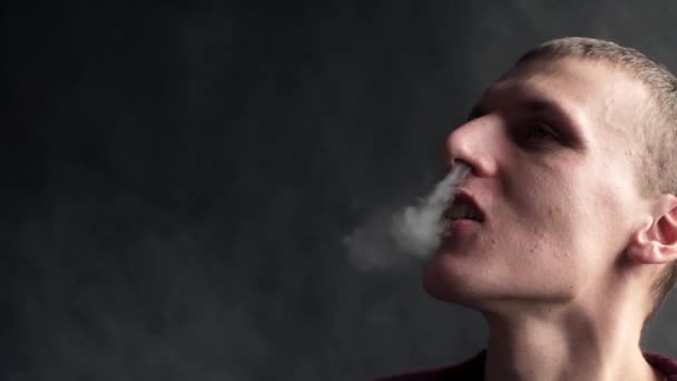 L'uomo fuma sigarette elettroniche e fa qualche nuvola di fumo, il ragazzo sta vaporizzando, e-cig e vaporizzando penna, brutti abbracci di persone — Video Stock