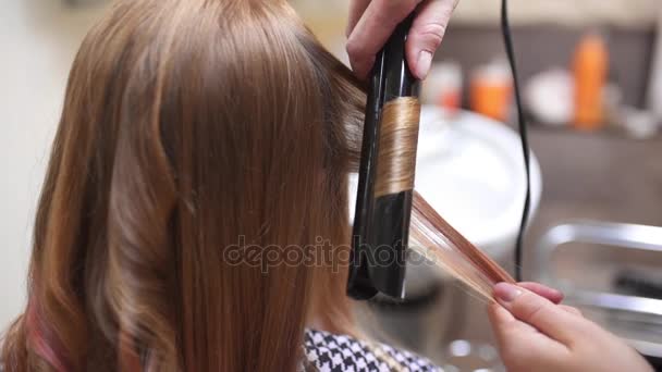 Парикмахер делает кудрявые волосы для женщины горячим керлингом, женщина в студии красоты, красоты и моды бизнеса — стоковое видео