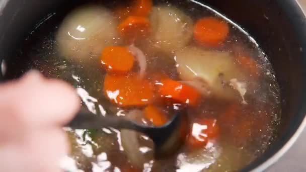 Chef-koks groentebouillon met wortel, ui en kruiden, slow motion koken — Stockvideo