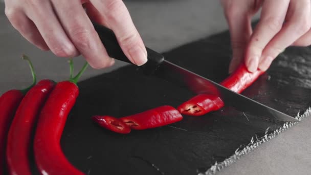 De kok plakjes hete chili pepers op de plaat, kruidig voedsel, maaltijden met groenten, vegetarische gerechten, thuis koken — Stockvideo
