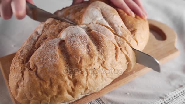 Huisvrouw sneetjes brood door lange mes op de houten plank, een familiediner, een brood van brood, bakkerijproducten, verse bakkerij — Stockvideo