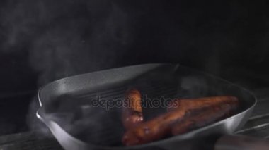 Sosis yemek yemek, et yemekleri, lezzetli yemekler, Şef mutfak, lokanta, yemek ağır çekimde dumanlı sıcak ızgara Pan kavurma
