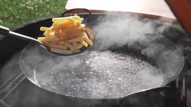 Bir sürü duman ve ateş, dışarıda yemek sıcak fast food yemek ızgara üzerinde kaynar yağda kızarmış patates tava