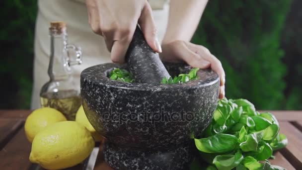 Huisvrouw maalt de basilicum voor pestosaus buiten, koken, voedsel, kruidig voedsel, vegetarische maaltijd — Stockvideo