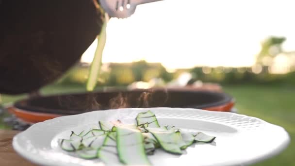 Zucchini panggang di piring dekat api di luar, panggangan dan barbekyu, makanan vegetarian, koki membuat salad, memasak di luar, makanan diet sehat — Stok Video