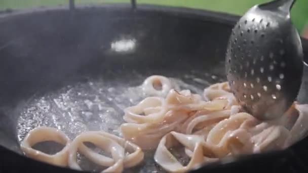 Ringar av calamari stekning i kokande olja på den öppna elden, grillar bläckfisk, skaldjur måltid, asiatisk mat, matlagning utanför — Stockvideo